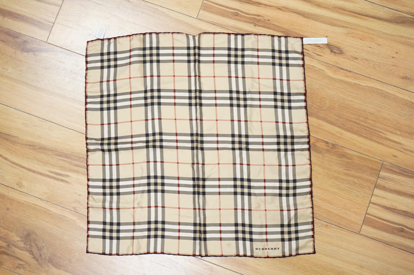 Three silk scarves comprising a Burberry check example, Christian Dior monogrammed and a Vakko abstract patterned example
